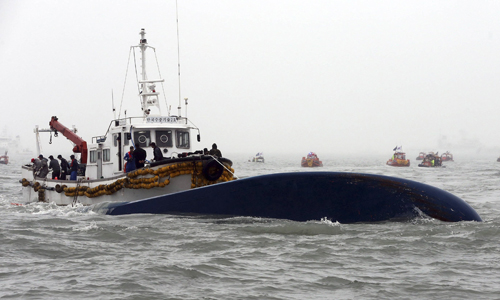 Nhân viên trên tàu cứu hộ của Hàn Quốc đang tìm cách bơm không khí vào trong phà. Ảnh: Reuters.
