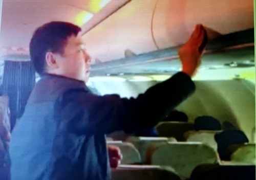 Sau khi lục lọi lấy đồ, hành khách Trung Quốc Zhang Giang trả chiếc valy về chỗ cũ.
