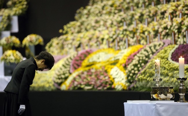 Tổng thống Hàn Quốc Park Geun Hye dâng hương và cúi đầu trước bàn thờ chung của hàng trăm em học sinh thiệt mạng sau vụ chìm tàu. Ảnh: Yonhap.