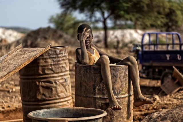 Sau nhiều giờ lao động vất vả ở mỏ vàng, Nuru Haruna, 13 tuổi, ngâm mình trong một thùng nước.