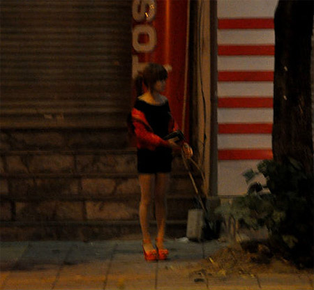 Một gái mại dâm đứng chờ khách trên đường.